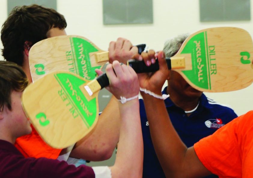 The youth of the YCDC tapping paddles in the "good game" gesture 